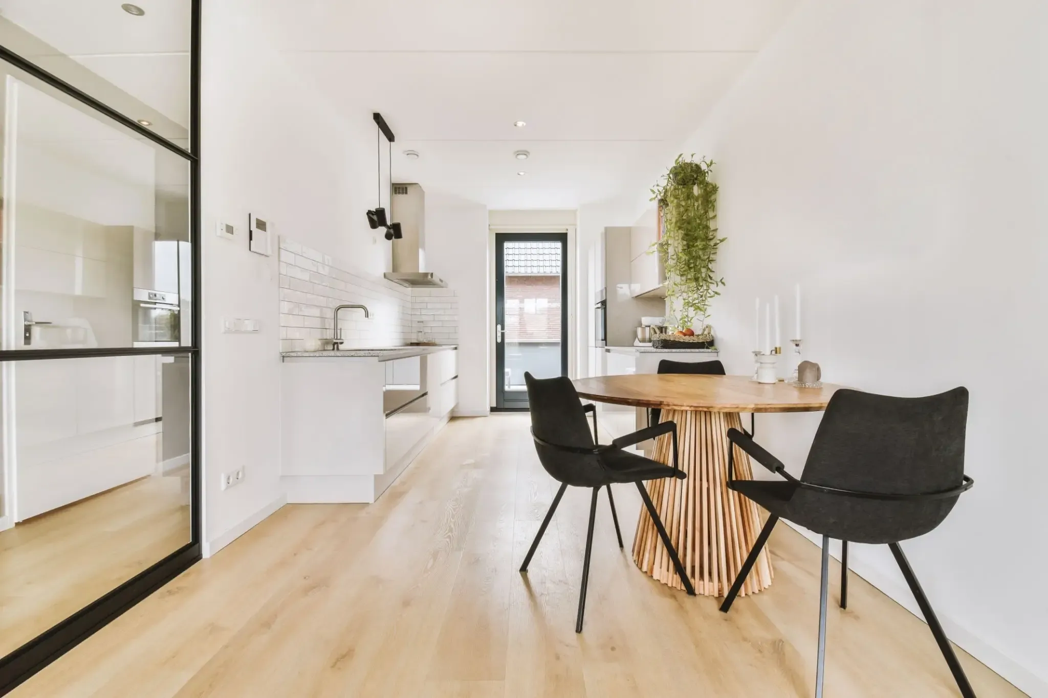 102 sec A dining room with black chairs and white walls.