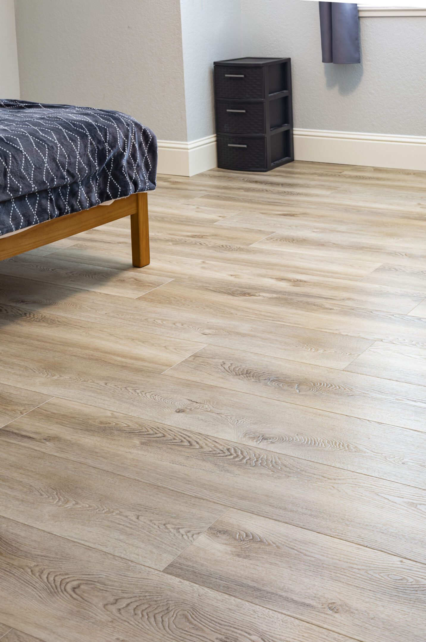 A bedroom with hard wood floors and a bed.