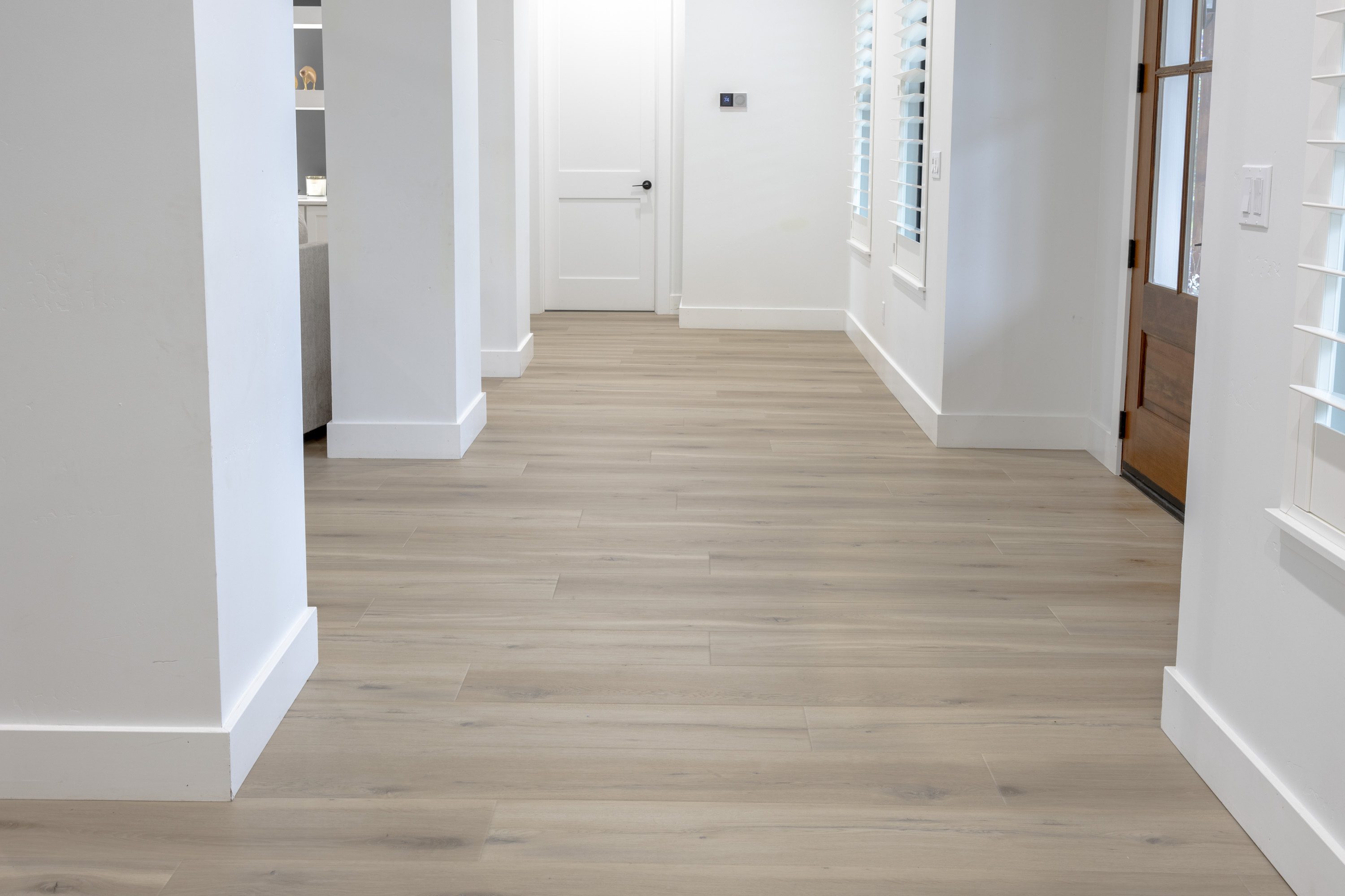 A hallway with white walls and wooden floors.