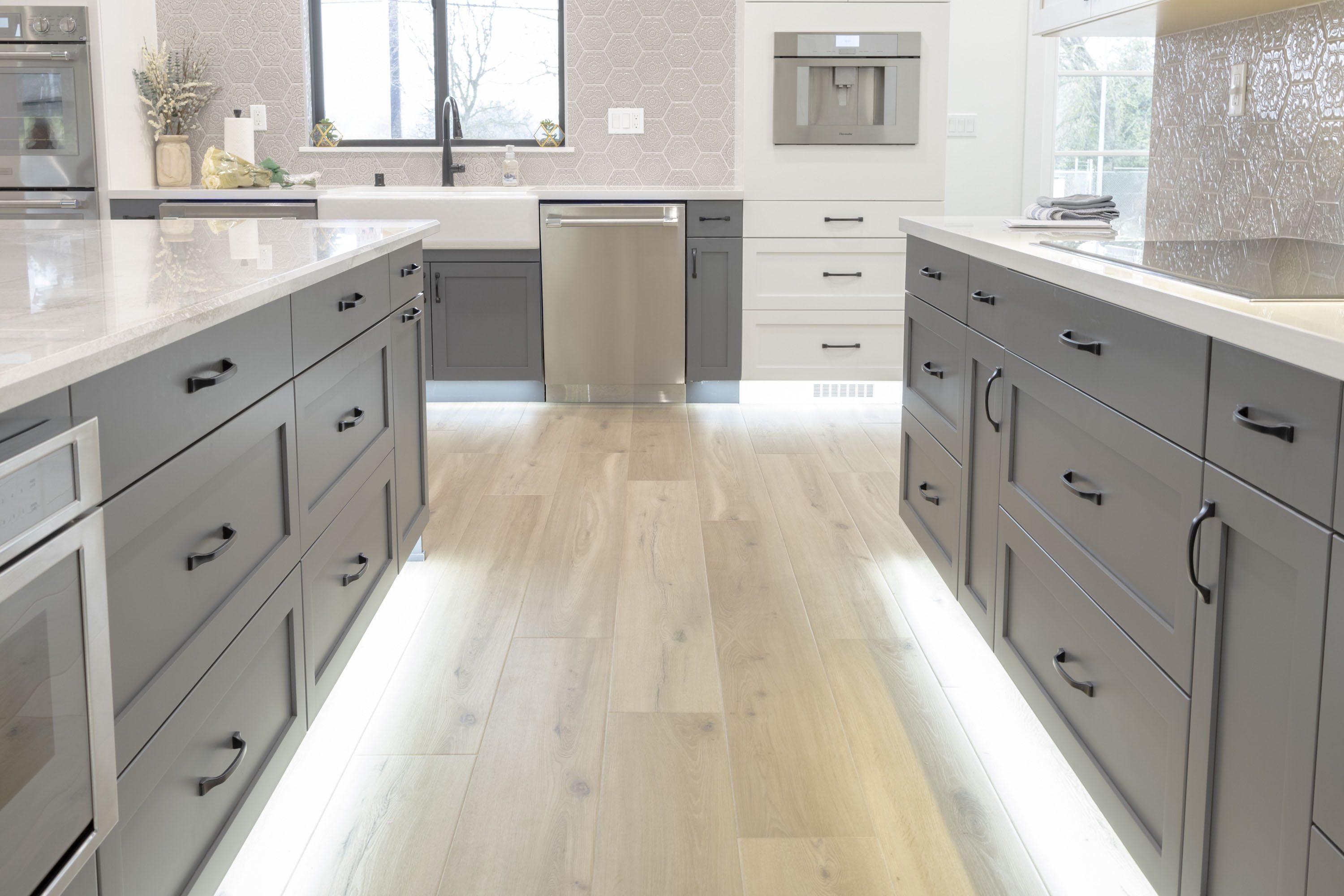 A kitchen with two large gray cabinets and white counters.