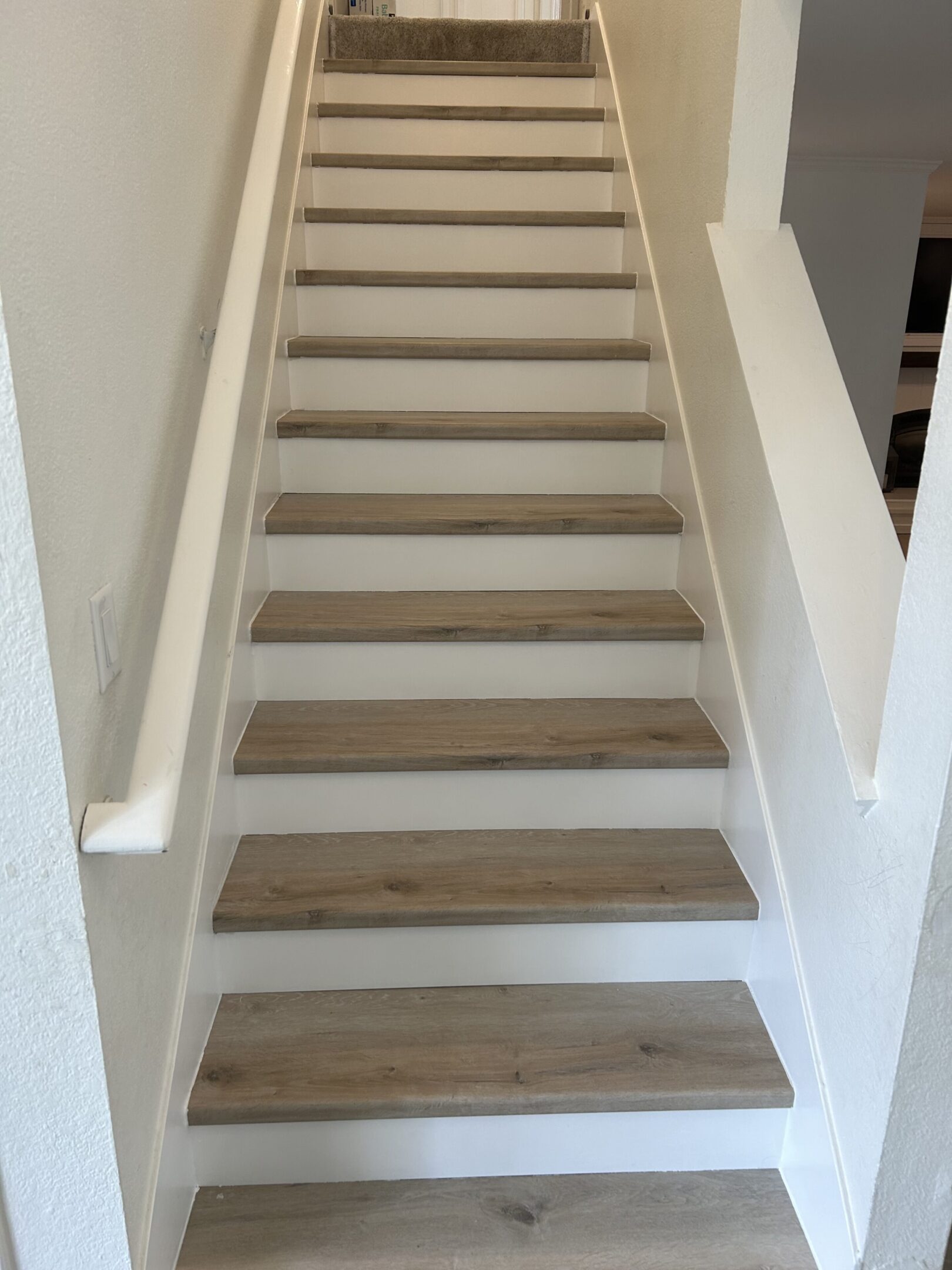 A staircase with wooden steps and white walls.