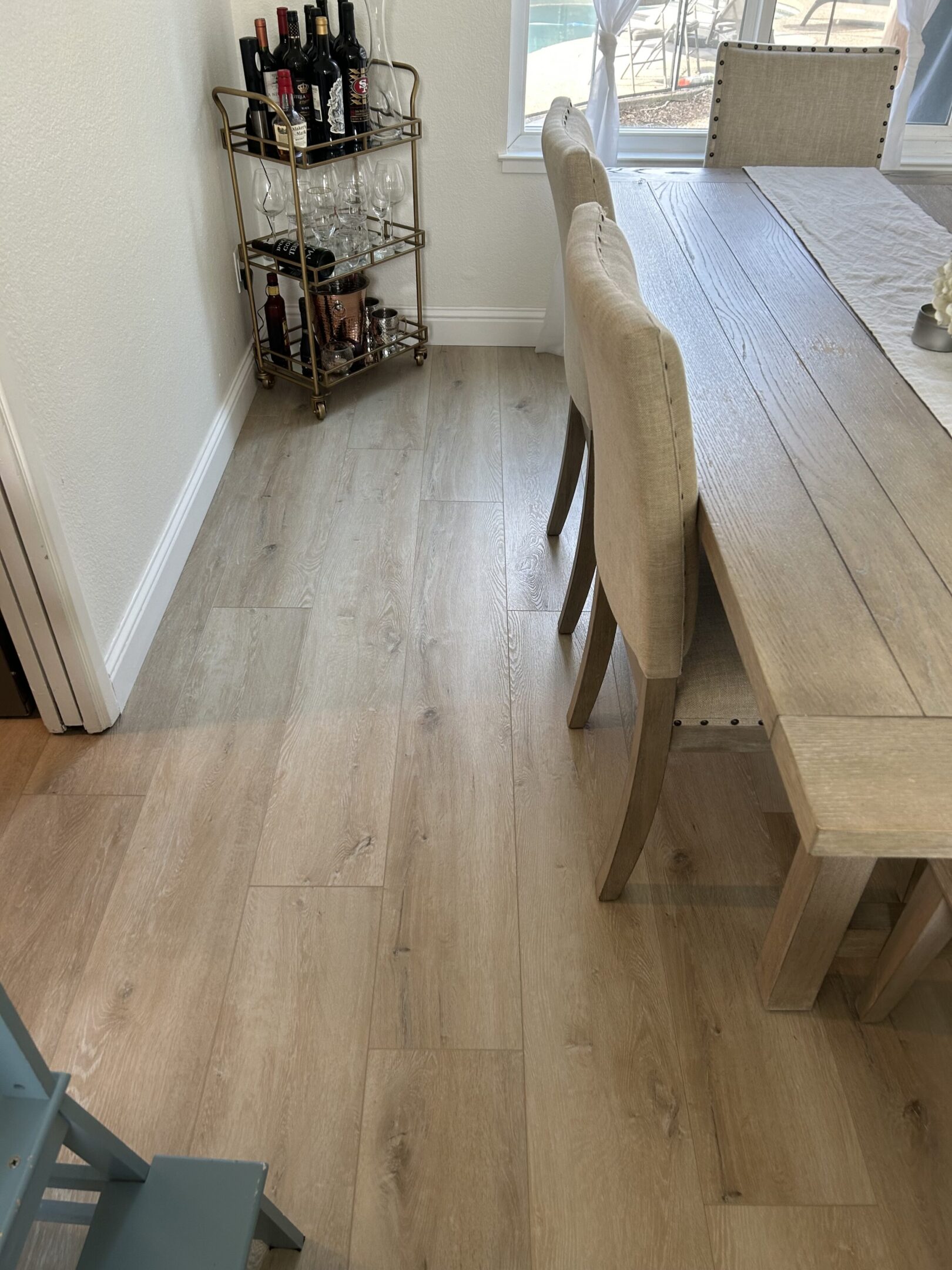 A dining room table and chairs in the corner of a kitchen.