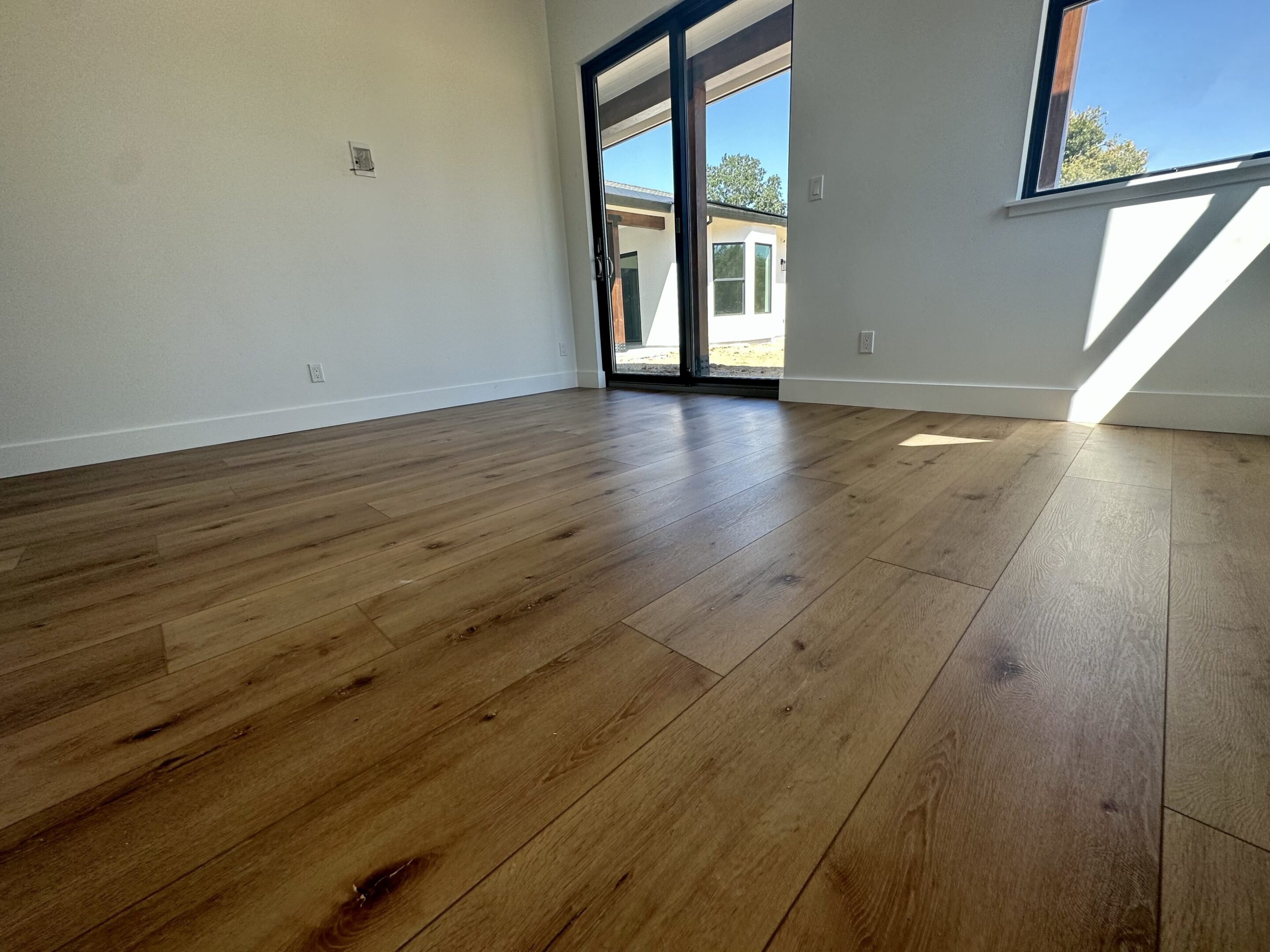 A room with wooden floors and sliding glass doors.