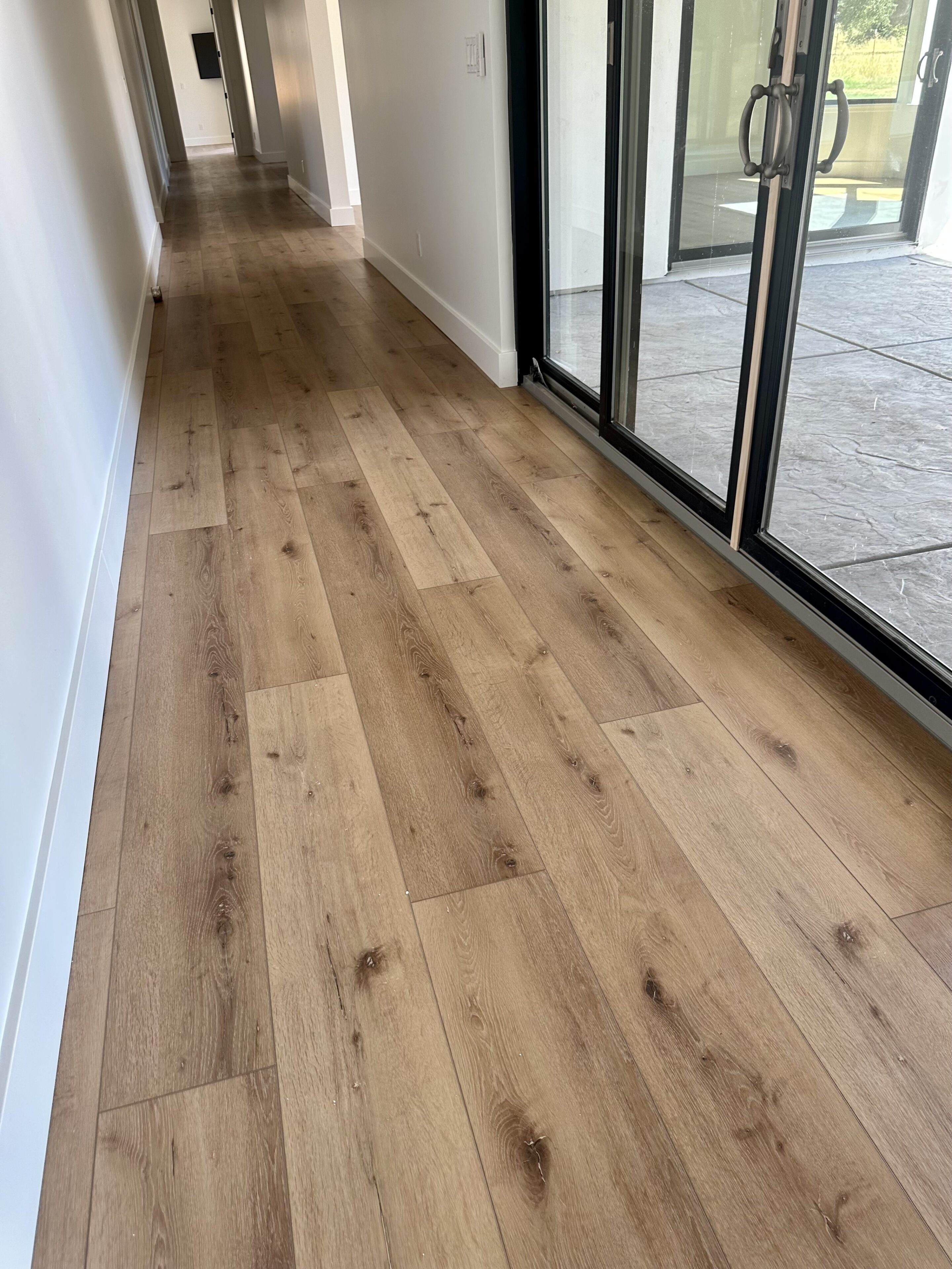 A hallway with sliding glass doors and wood floors.