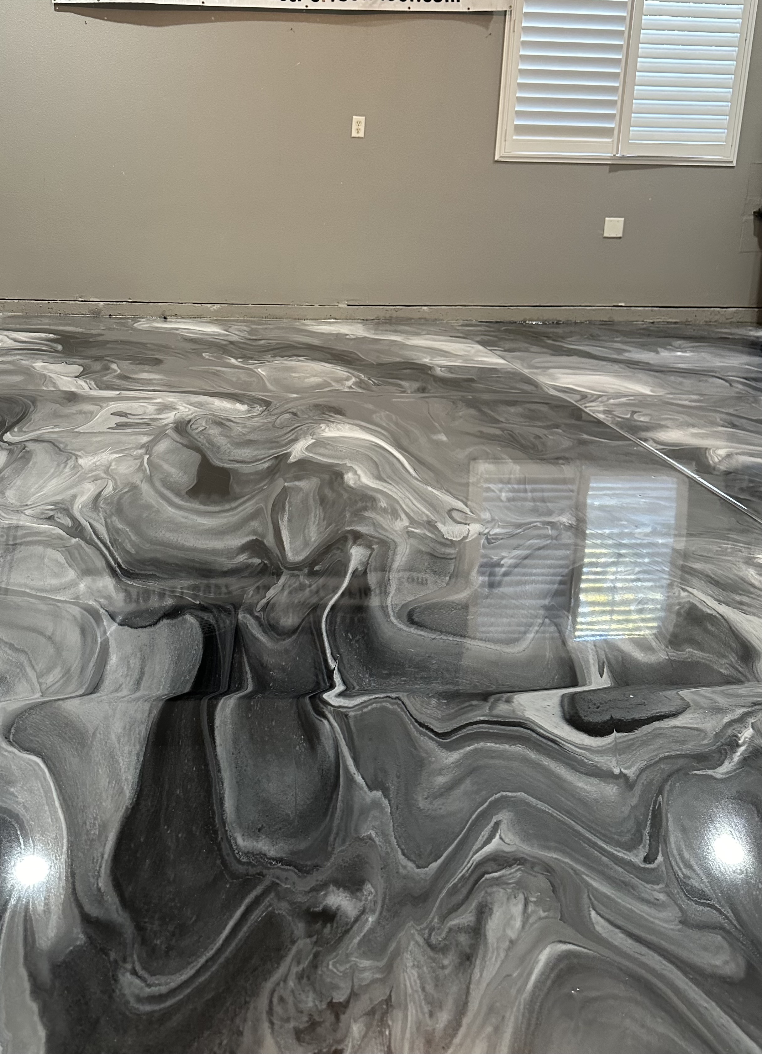 A black and white photo of a floor with some type of liquid