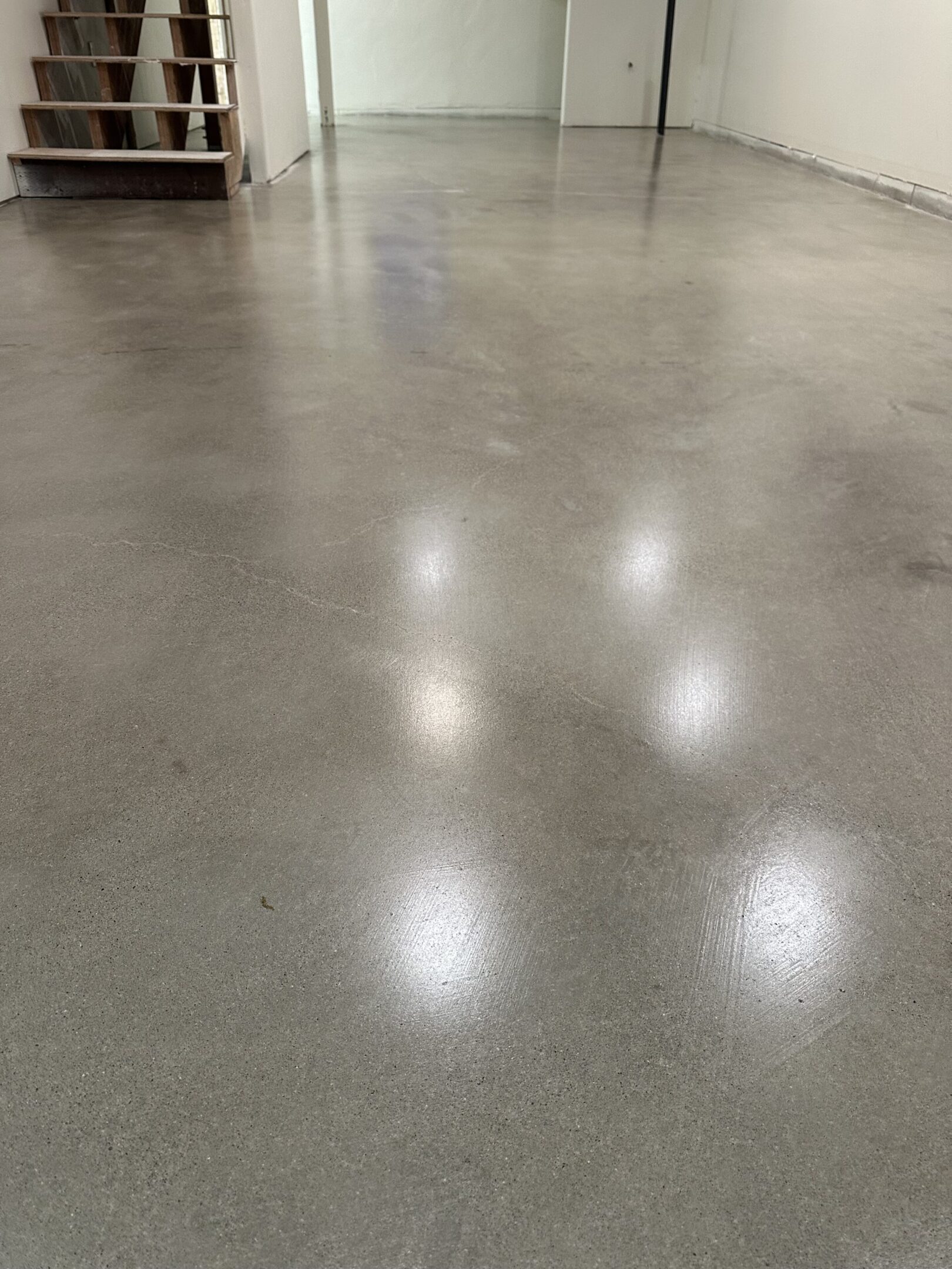 A floor with white polished concrete floors and a light.