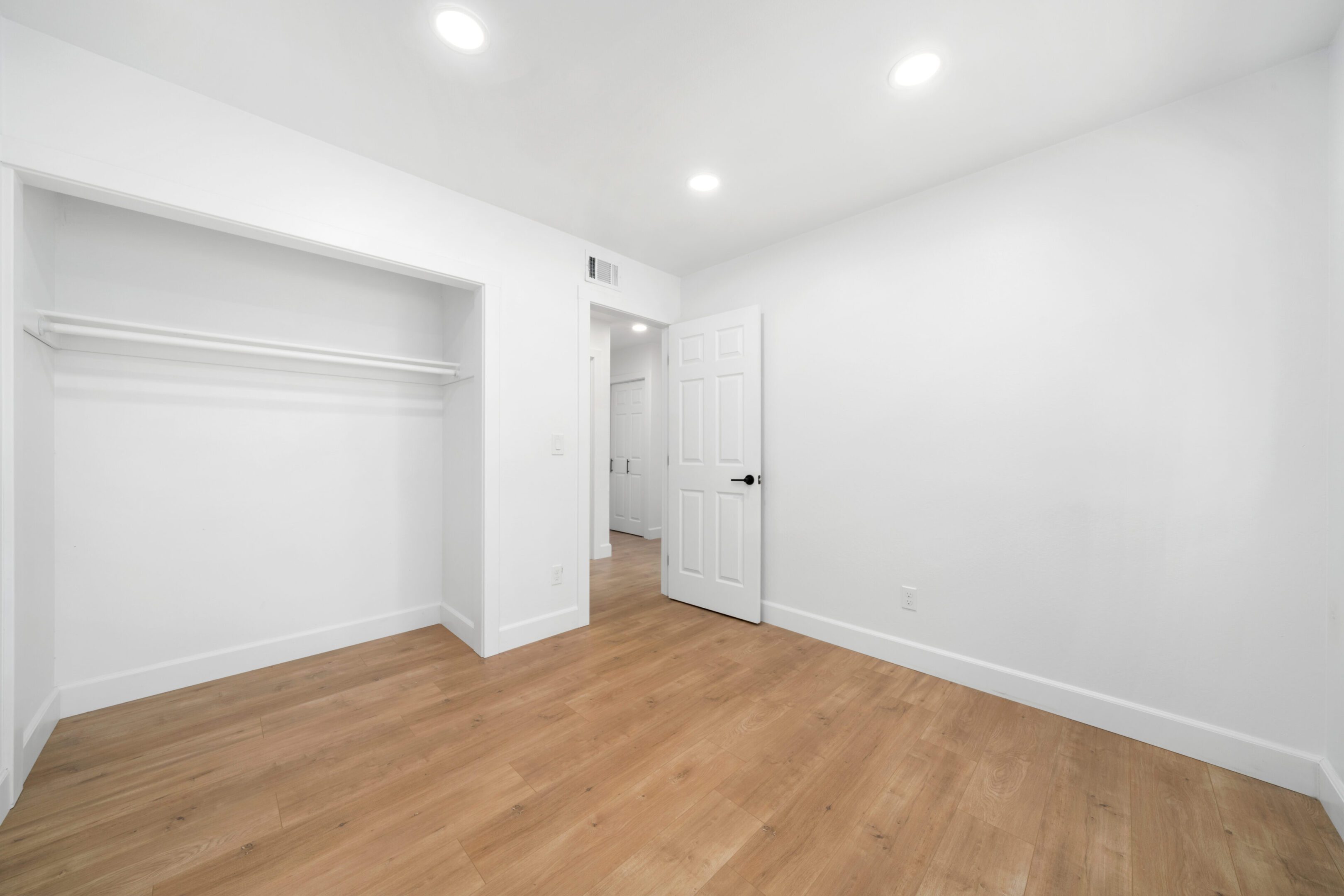 A room with white walls and wooden floors.