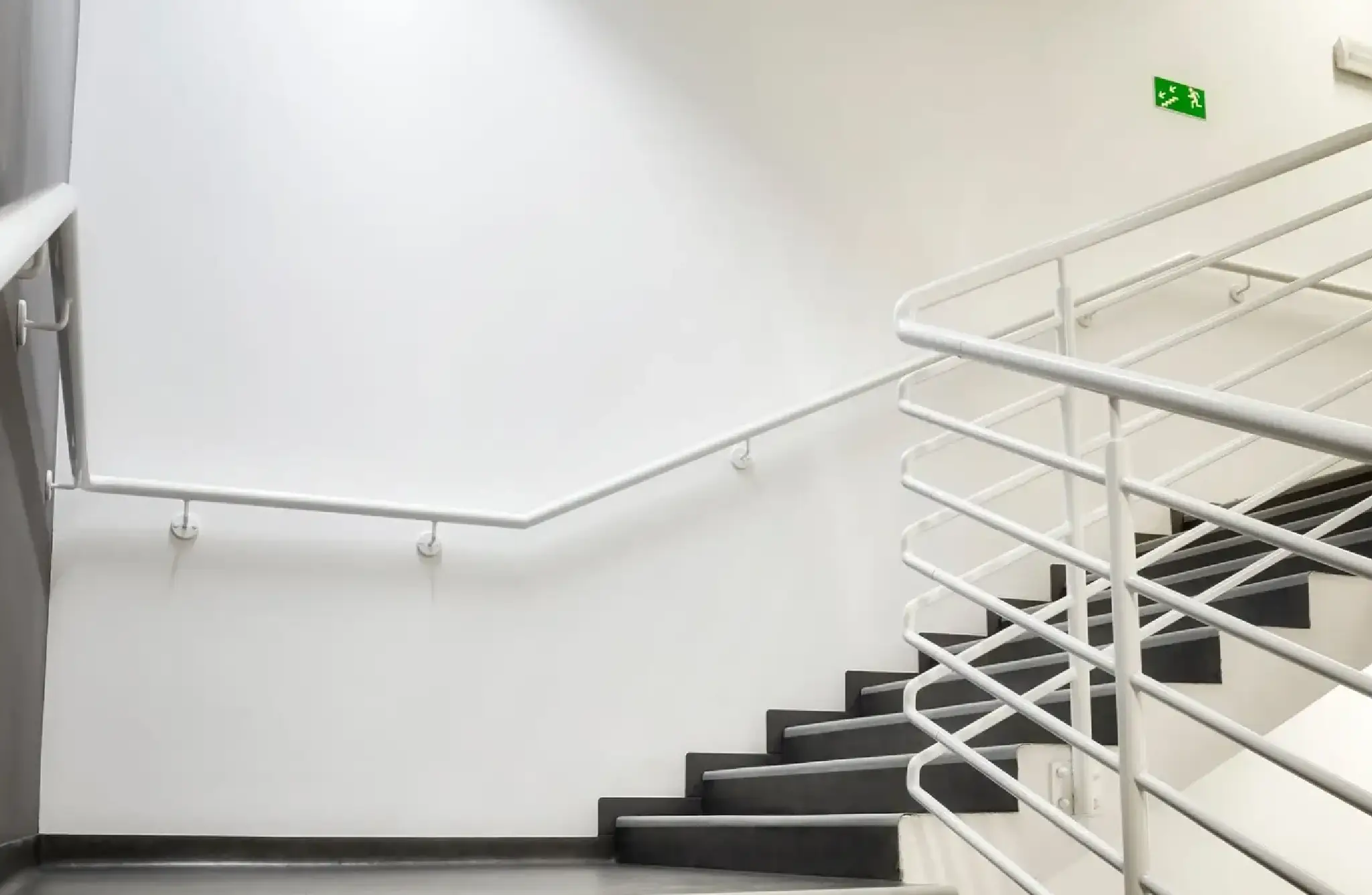 A white staircase with black steps and handrails.